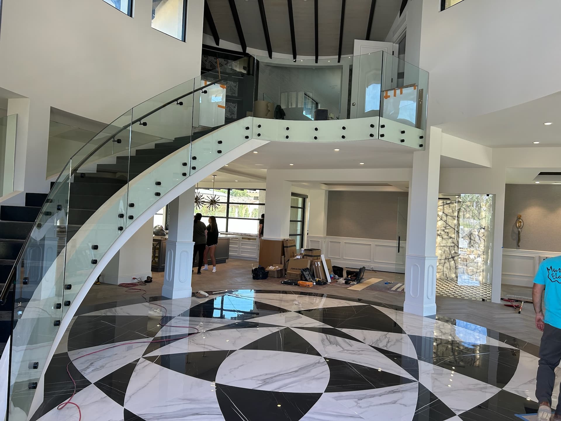 Grand two-story curved staircase with marble floor