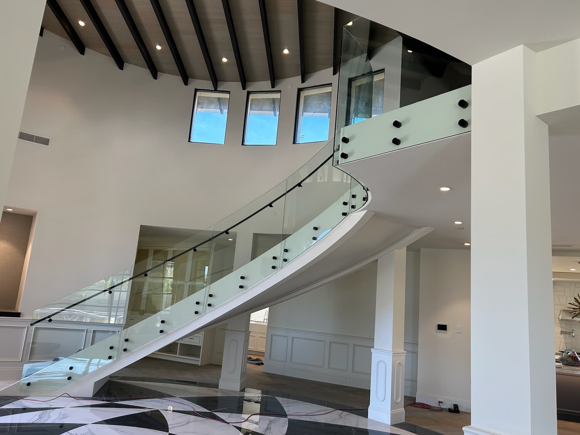 Curved glass railing sweeping to second floor