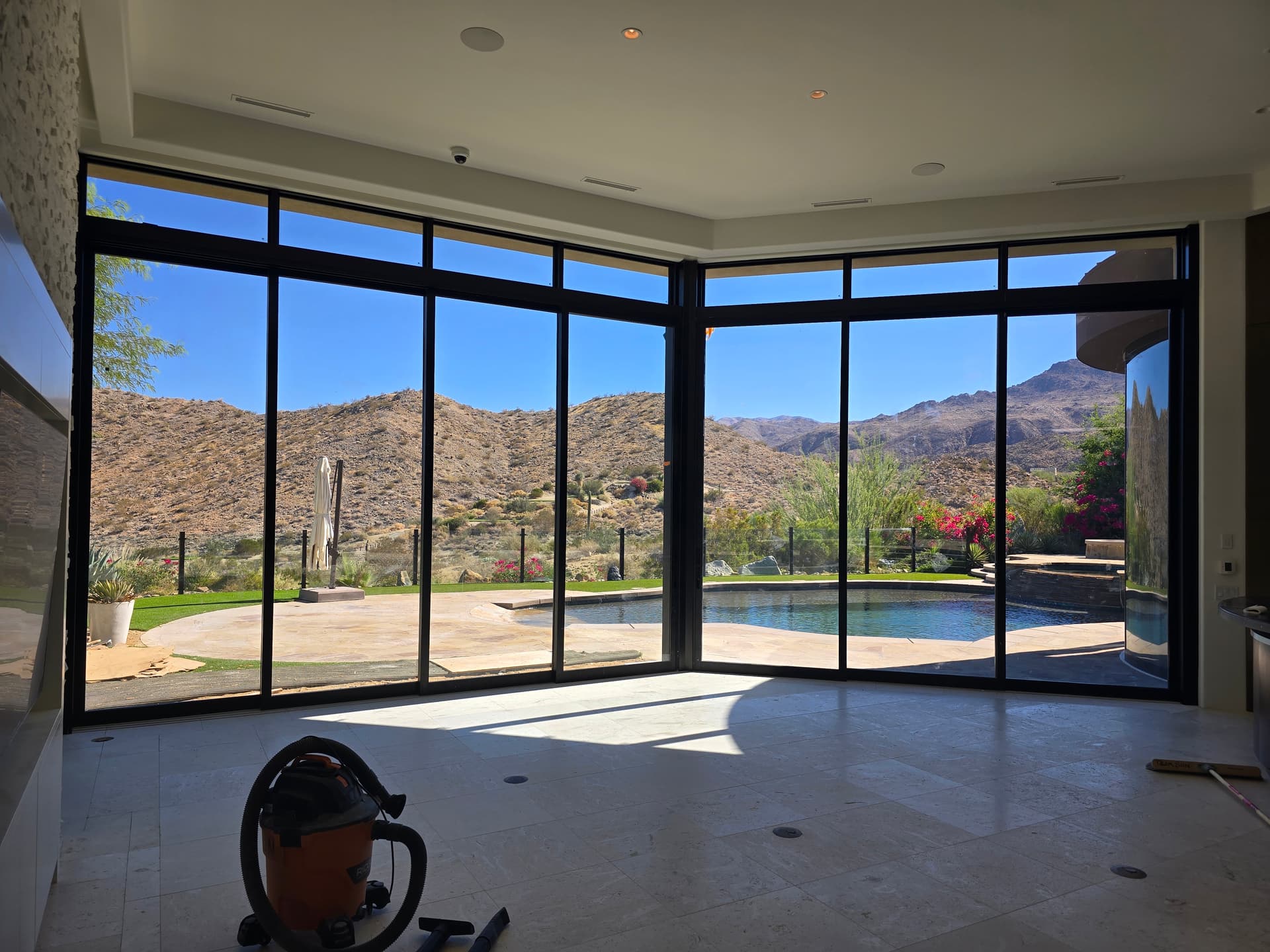 Corner floor-to-ceiling glass wall with mountain view