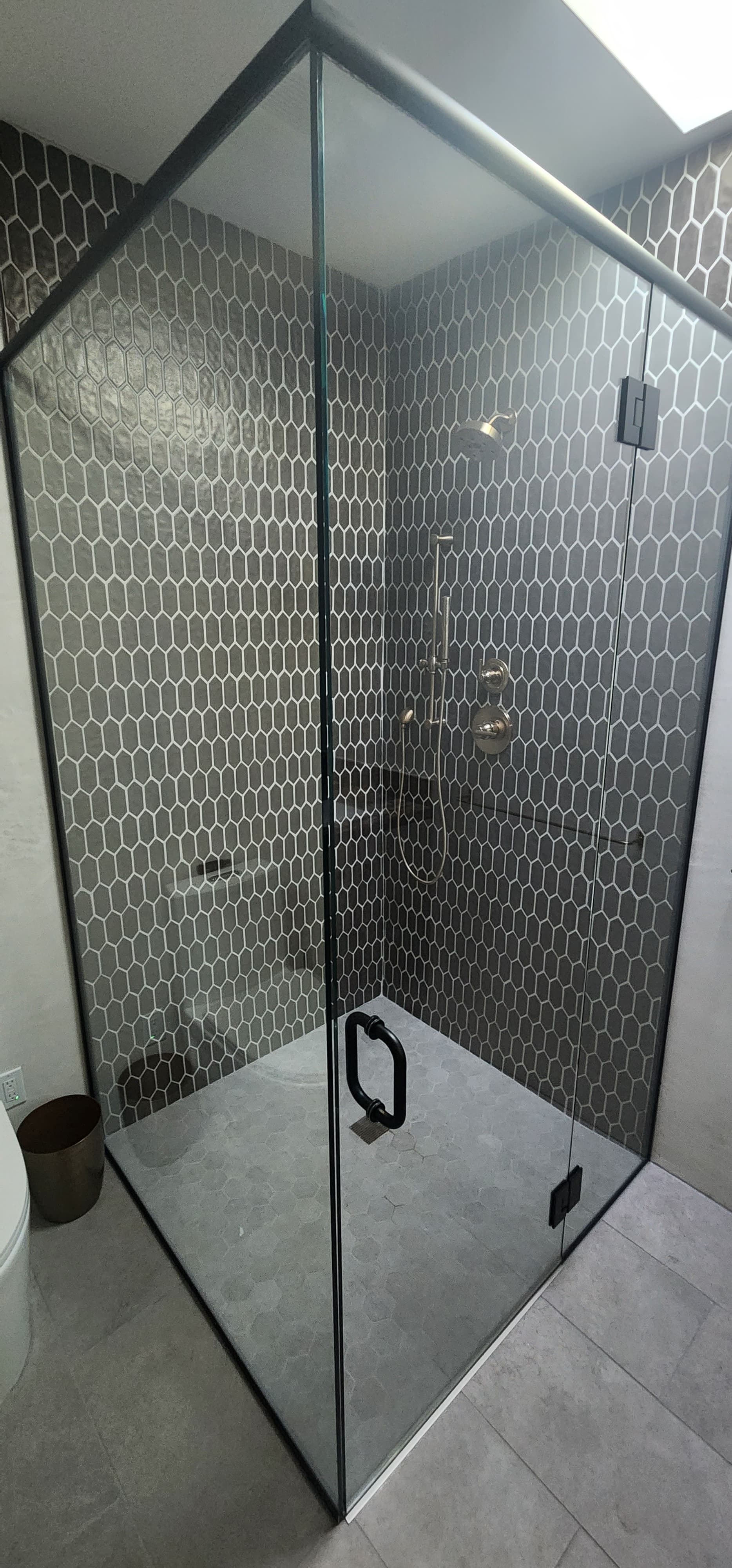 Frameless corner shower enclosure with black frame