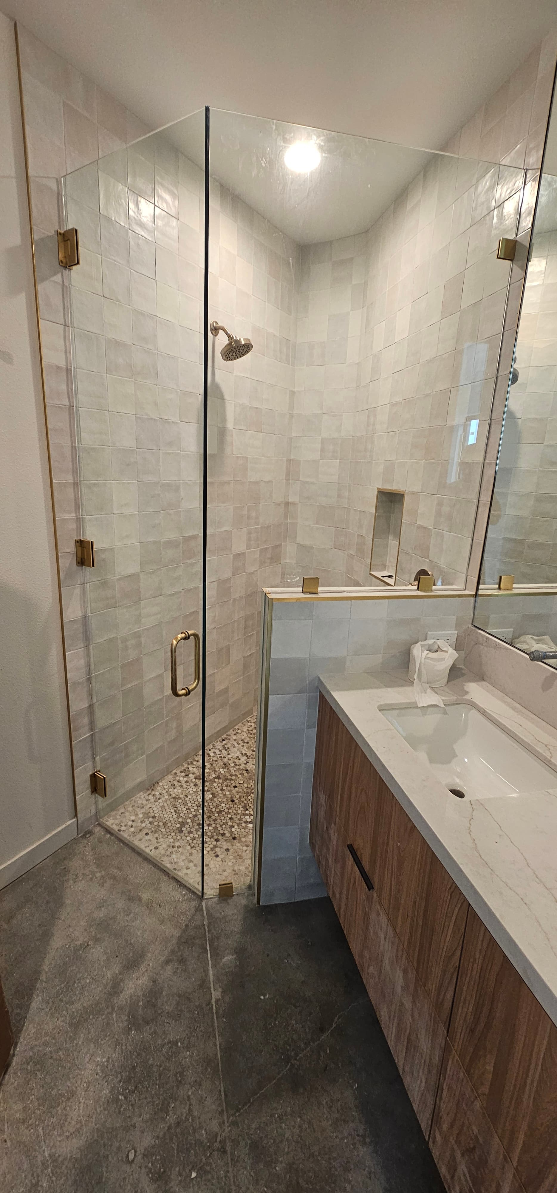 Frameless shower enclosure with brass hardware