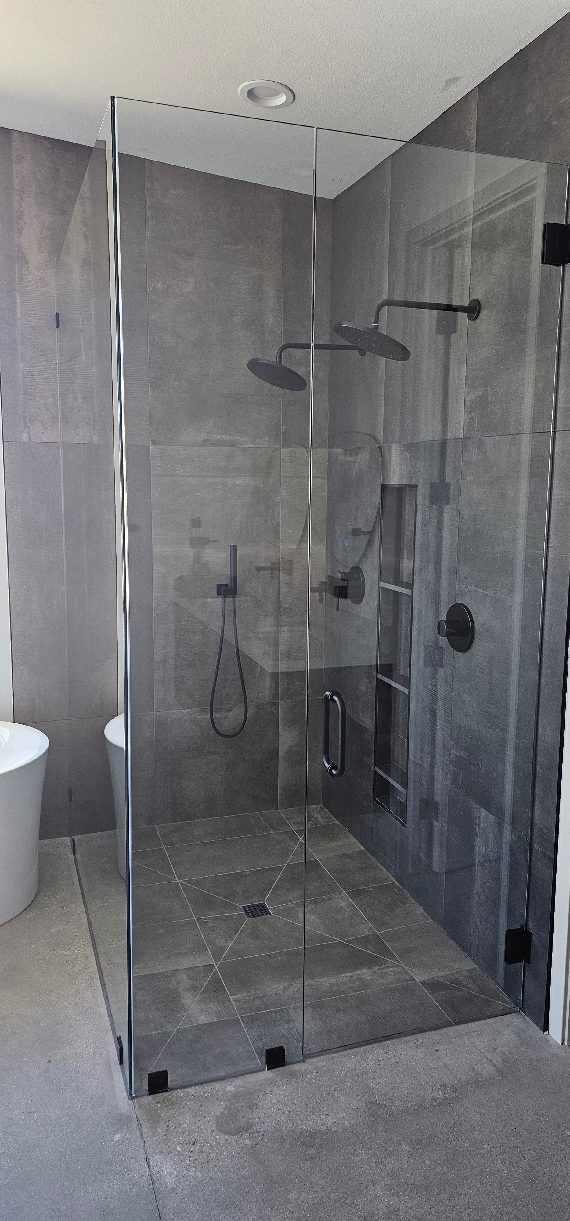 Large frameless corner shower with dual rain heads